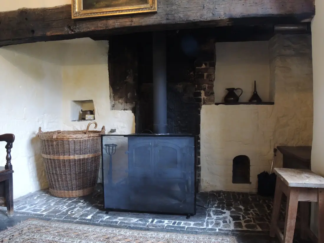 A stone-flagged hearth in an inglenook fireplace